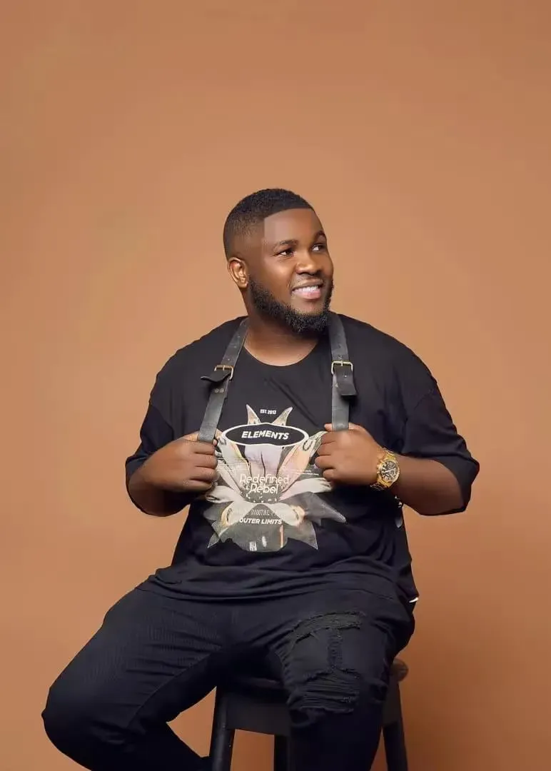 Odior, photographer and videographer at Remmy Best Photos, in a portrait on a brown backdrop